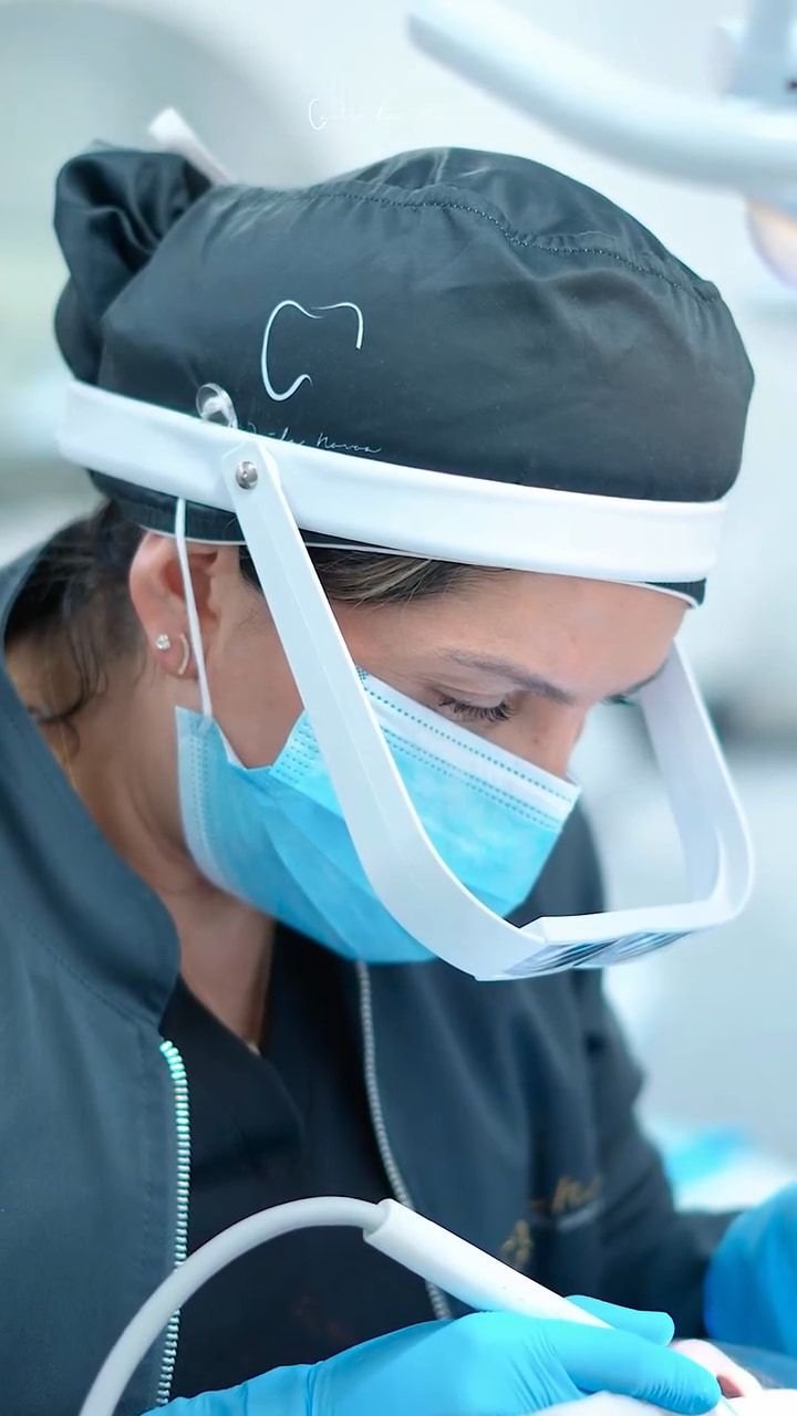 Especialista de la clínica trabajando con lupas y protector facial