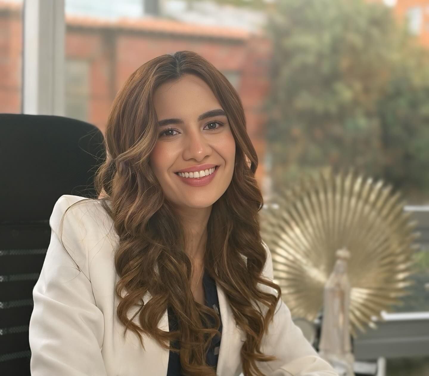 La Dra. Camila Novoa en su consultorio, con blazer blanco